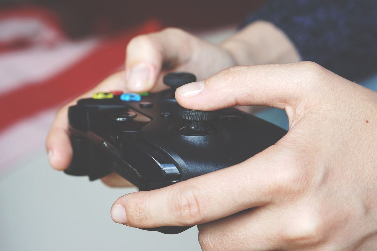 Mains tenant une manette de jeu